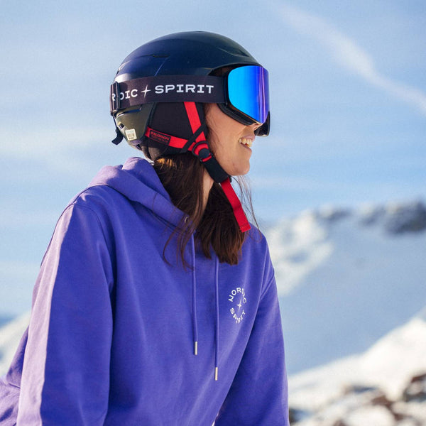 Eine Frau in Skiausrüstung und blau verspiegelter Nordic Spirit Skibrille