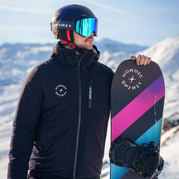 Ein Mann in schwarzer Skikleidung mit einem Nordic Spirit Snowboard in einer verschneiten Berglandschaft