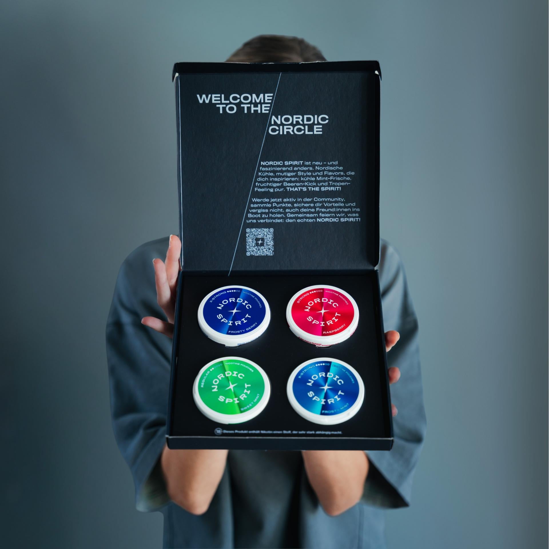 Vier Nordic Spirit Dosen in Schachtel präsentiert von Person