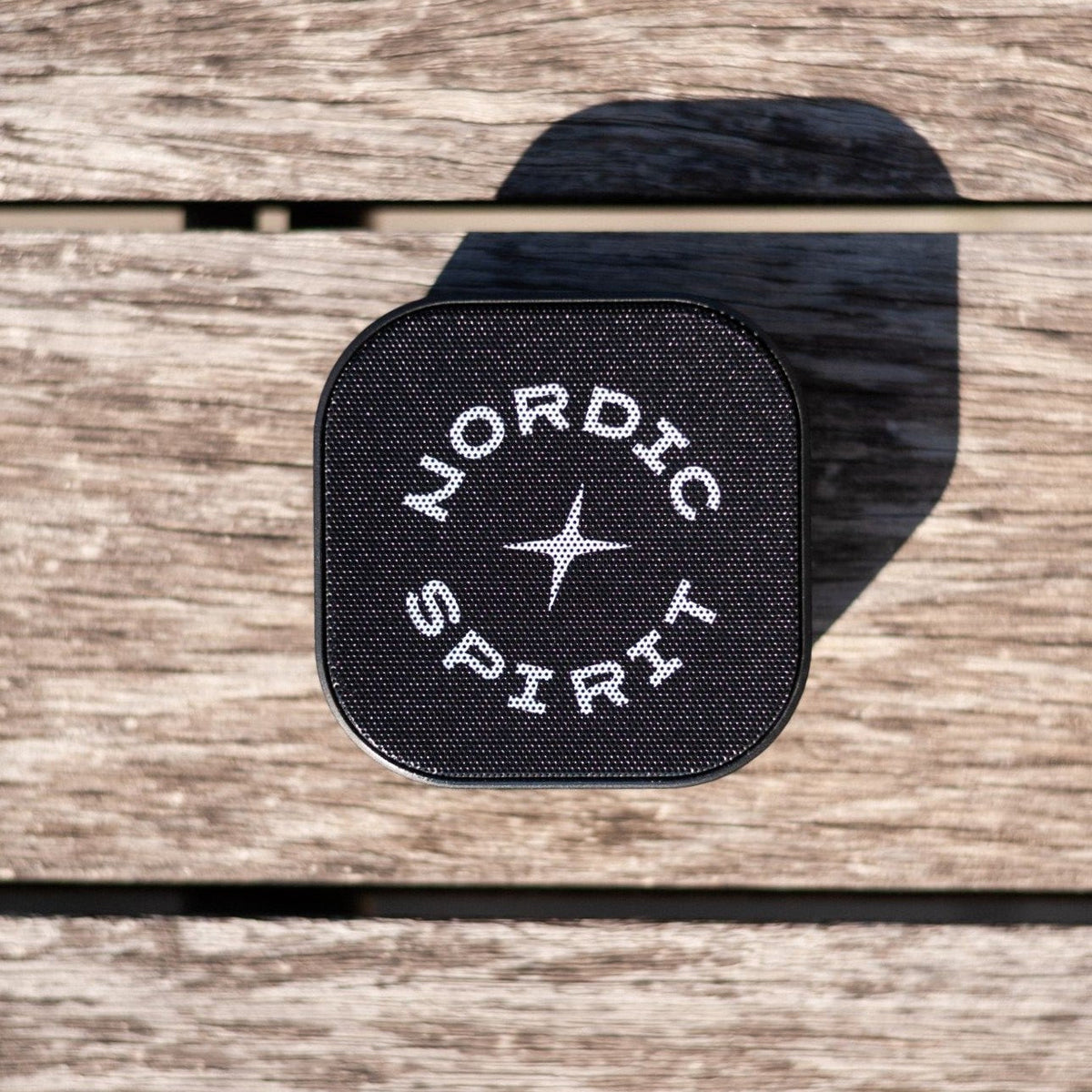 Schwarzer Nordic Spirit Speaker auf einer Holzoberfläche.