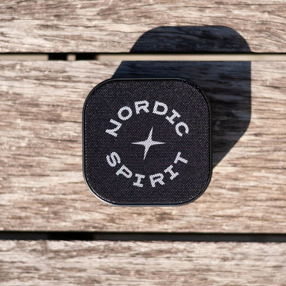 Schwarzer Nordic Spirit Speaker auf einer Holzoberfläche.